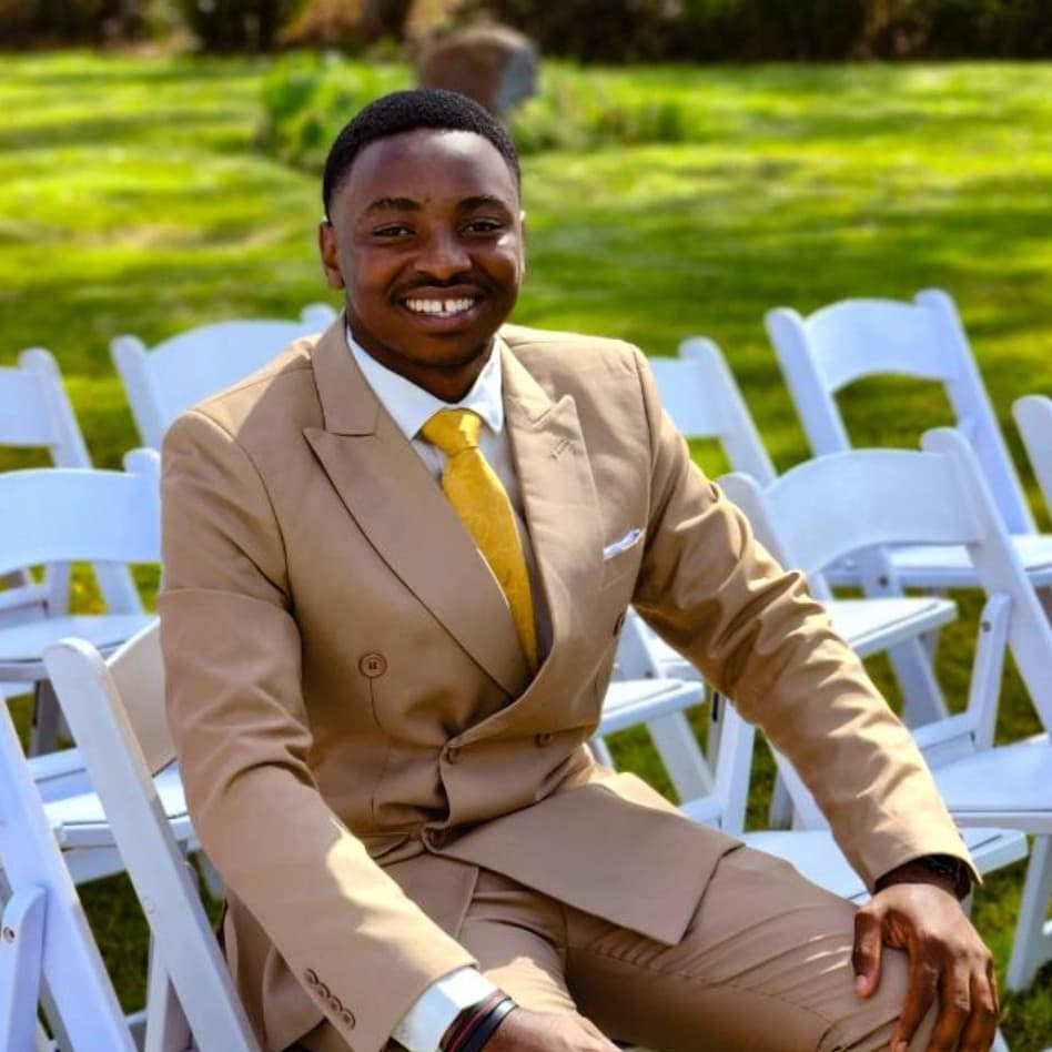 Dylan Dzenga in a tan suit, smiling outdoors